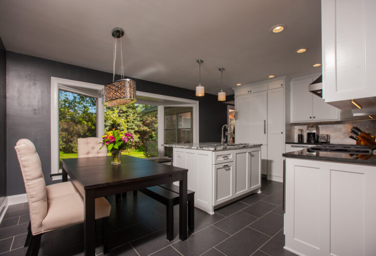 Kitchen dining area with freshly painted dark gray walls and contrasting white cabinets and trim.