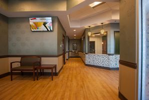 Two-tone interior paint job in a healthcare lobby with textured gray upper walls and beige lower walls.
