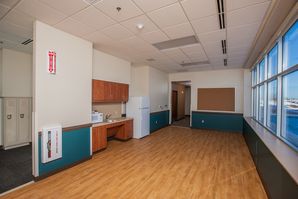 Freshly painted office breakroom with white upper walls and teal lower drywall.