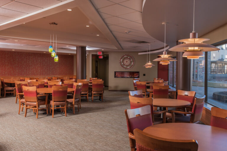 Freshly painted beige and red accent walls in a spacious dining hall with modern lighting and furniture. Edina Minnesota.