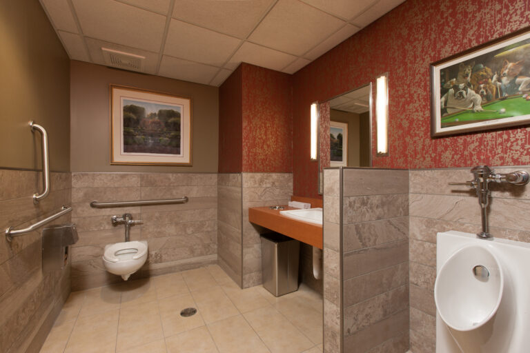 hung wallcoverings in upper walls in a commercial restroom with tiled lower walls and fixtures. St. Paul Minnesota.
