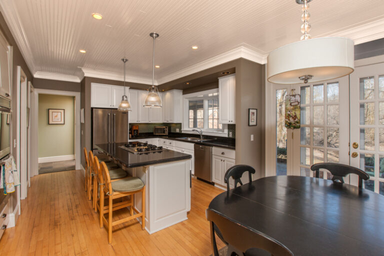 Kitchen featuring painted taupe walls, white beadboard ceiling, and white cabinetry.