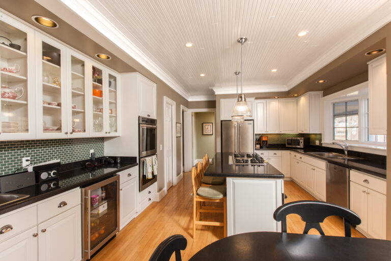 Kitchen with freshly painted taupe walls, white cabinetry, and a white beadboard ceiling.