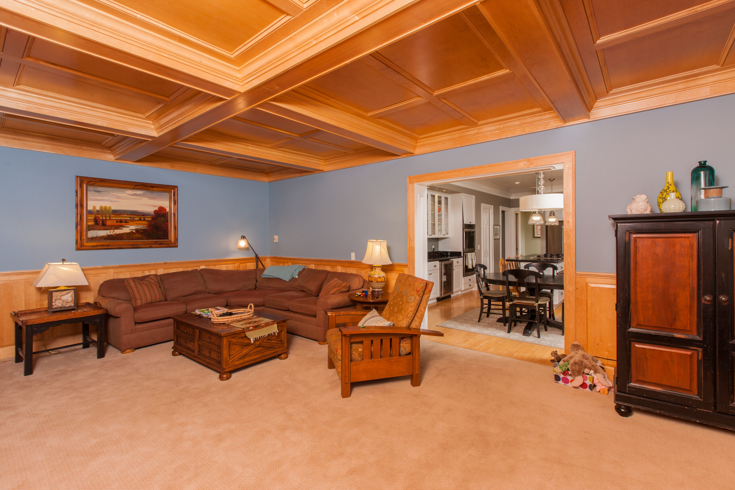 Blue painted walls and stained wood coffered ceiling in a traditional living room with wainscoting. Also painted walls and ceiling in Macalister Groveland in St. Paul MN.