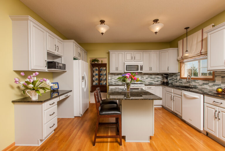 Light gray painted wooden kitchen cabinets and island in a finished interior painting project. Painted interior walls in St. Paul MN, in highland park area.