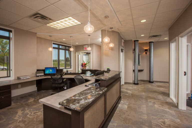 Freshly painted tan walls in a professional office reception area with a granite-topped desk.