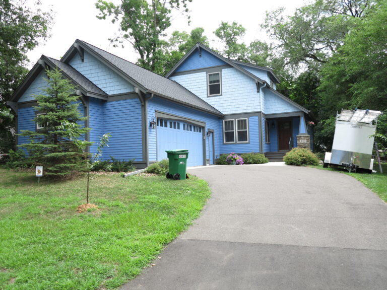 A blue residential home with freshly painted exterior siding, gray trim, and attached garage in Saint Paul, MN.