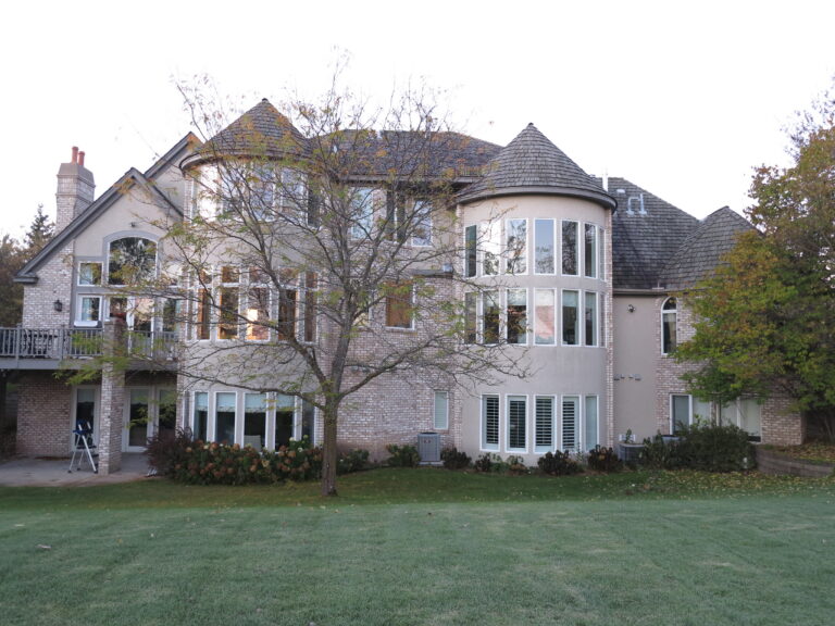 Large brick and stucco luxury home with turret after exterior painting, Saint Paul, MN residential repaint