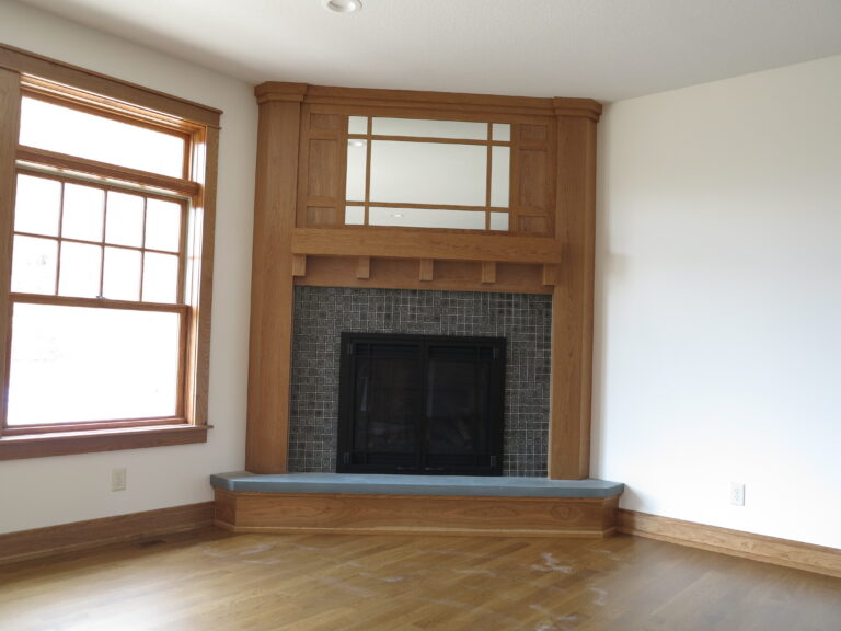 Freshly painted white walls in a room with a wood corner fireplace and matching window trim.
