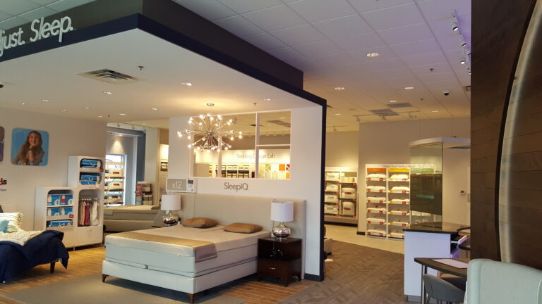 Interior painting of a modern mattress showroom with crisp white walls, warm lighting, and clean retail displays in Saint ...