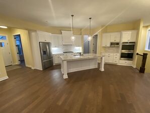 Freshly painted pale yellow walls in a modern kitchen featuring white cabinetry and an island.