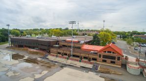 Aerial view of commercial building exterior painting project in Saint Paul, MN, featuring red trim and wood facade details.
