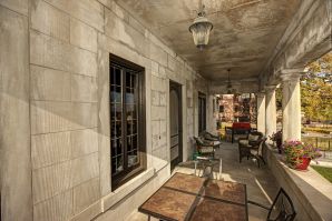 Elegant stone exterior painting on a historic commercial building's covered porch with lanterns in Saint Paul, MN.
