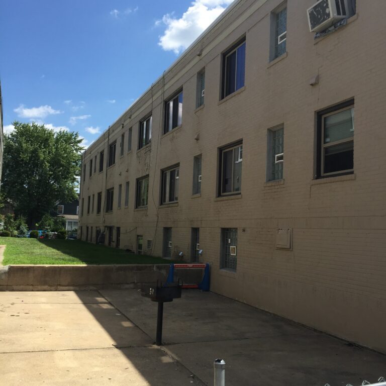 Exterior painting of a beige brick multi-story apartment building with windows and AC units in Saint Paul, MN