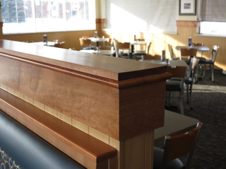 Warm wood stain finish on restaurant booth divider showcasing interior commercial woodwork painting in Saint Paul dining s...
